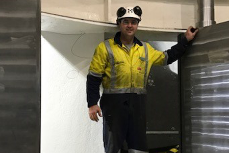 A man standing in front of a large piece of machinery