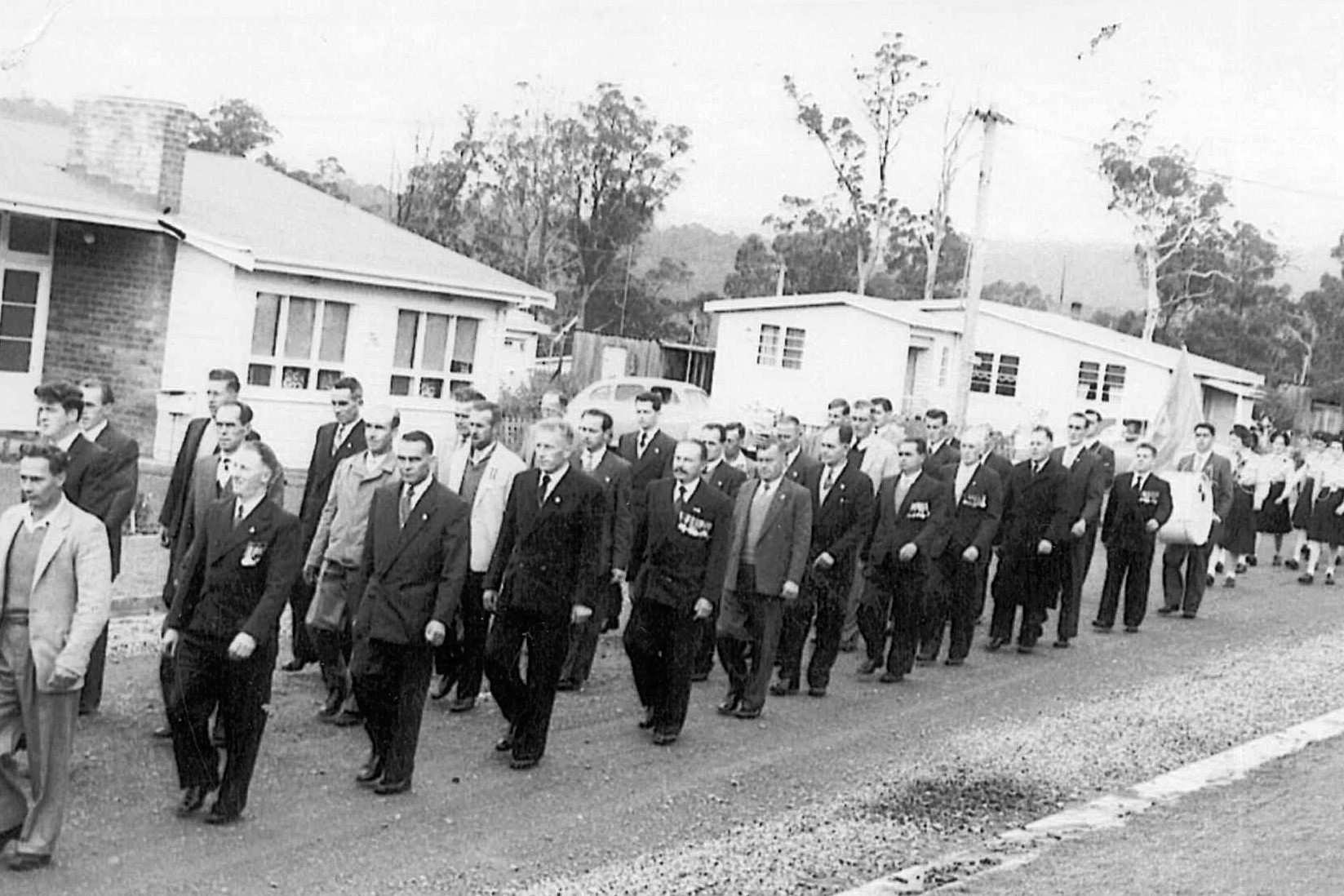 Black and white image of men marching in an ANZAC Day parade at Wayatinah