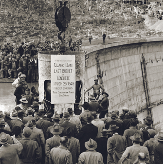 Historical image of construction of crowds at Clark Dam. A bucket is being held up &quot;Clark Dam last bucket of concrete, March 25 1949&quot;